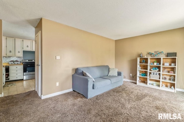 living area with carpet, baseboards, and a textured ceiling