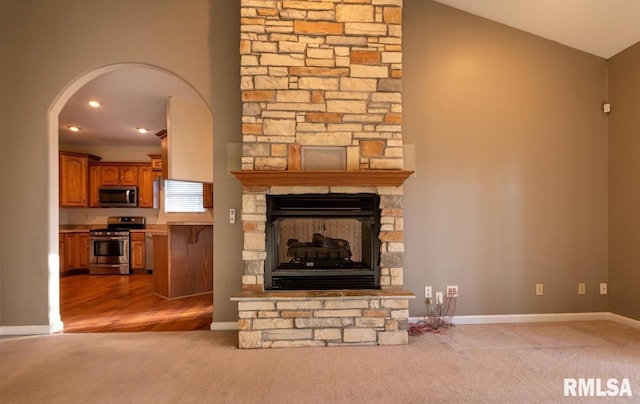 2505 Joel Dr, Herrin, IL 62948 - unfurnished living room featuring carpet, arched walkways, baseboards, a fireplace, and lofted ceiling