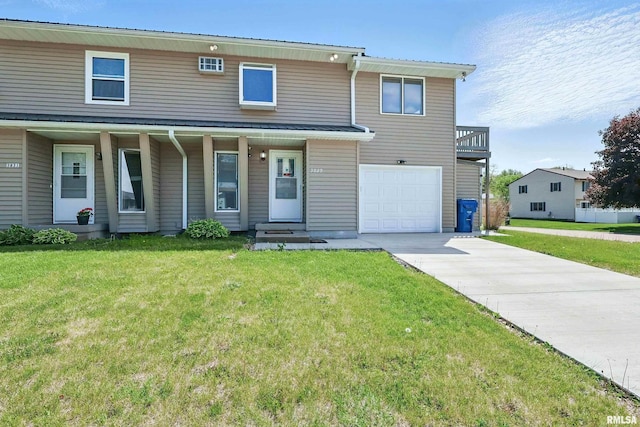 view of front of home with an attached garage, a front yard, concrete driveway, and a porch