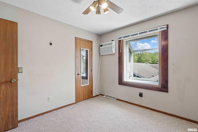 unfurnished room featuring baseboards, an AC wall unit, and light colored carpet