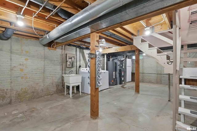 unfinished below grade area with water heater, a sink, washing machine and clothes dryer, and stairs