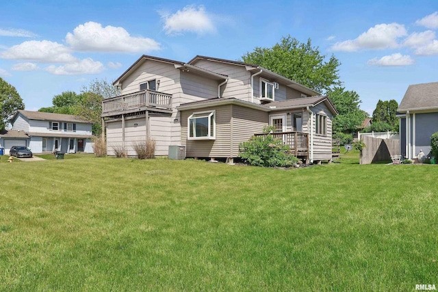 back of house featuring a lawn and a wooden deck