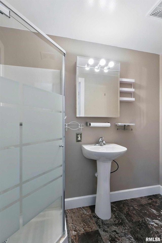 bathroom featuring baseboards and a stall shower