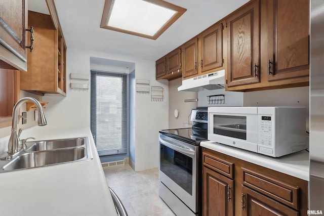 kitchen featuring electric stove, under cabinet range hood, white microwave, a sink, and light countertops