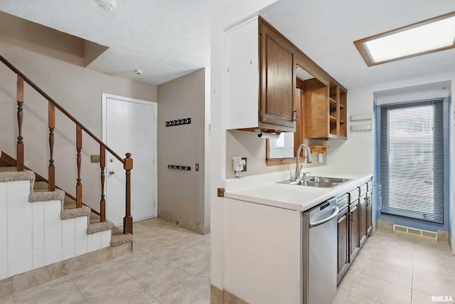 kitchen with a sink, stainless steel dishwasher, light countertops, open shelves, and light tile patterned floors