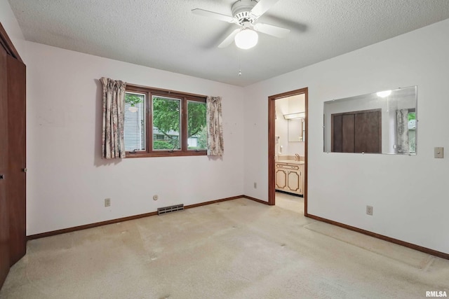 3816 Woodland Ct, Davenport, IA 52807 - unfurnished bedroom featuring light colored carpet, a textured ceiling, baseboards, ensuite bathroom, and a closet