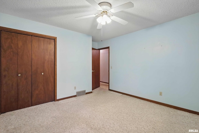 3816 Woodland Ct, Davenport, IA 52807 - unfurnished bedroom with a closet, baseboards, a textured ceiling, ceiling fan, and light carpet