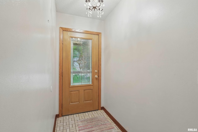 3816 Woodland Ct, Davenport, IA 52807 - doorway featuring baseboards and a chandelier