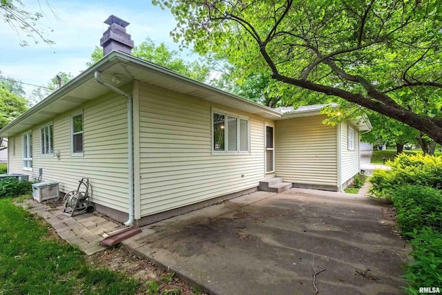 3816 Woodland Ct, Davenport, IA 52807 - view of property exterior featuring a patio, entry steps, and a chimney