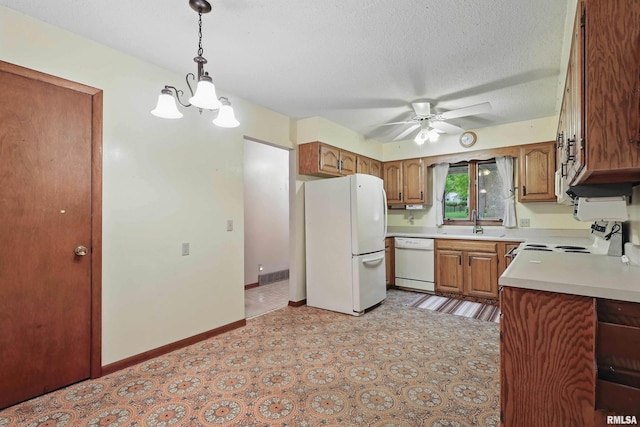 3816 Woodland Ct, Davenport, IA 52807 - kitchen with white appliances, brown cabinets, ceiling fan, a sink, and light countertops
