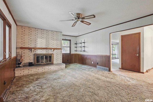 3816 Woodland Ct, Davenport, IA 52807 - unfurnished living room with healthy amount of natural light, ceiling fan, a textured ceiling, wood walls, and carpet floors