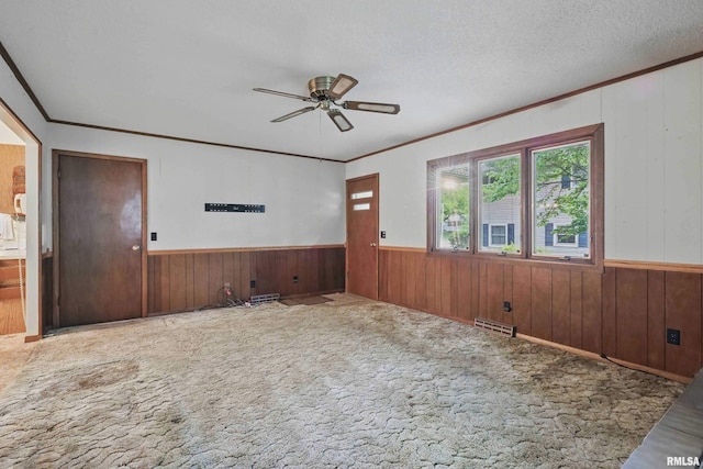 3816 Woodland Ct, Davenport, IA 52807 - unfurnished room featuring ornamental molding, a ceiling fan, wood walls, carpet floors, and a wainscoted wall