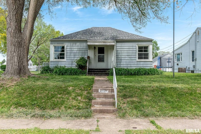 bungalow with central AC and a shingled roof