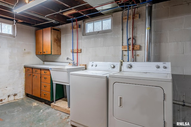 clothes washing area featuring separate washer and dryer and cabinet space