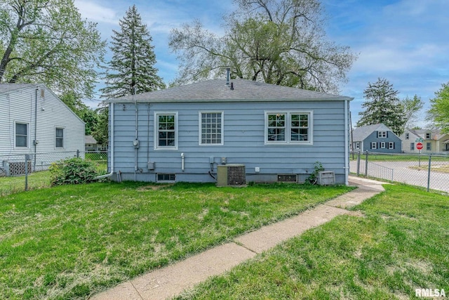 back of house featuring cooling unit and a shingled roof