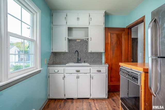 kitchen featuring freestanding refrigerator, a sink, black dishwasher, and dark wood-style flooring