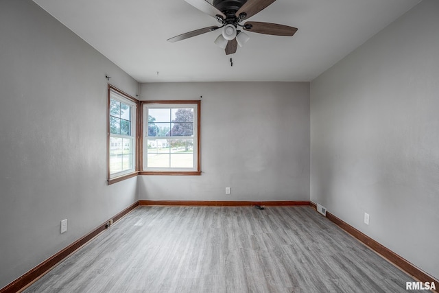 spare room with wood finished floors, baseboards, and a ceiling fan