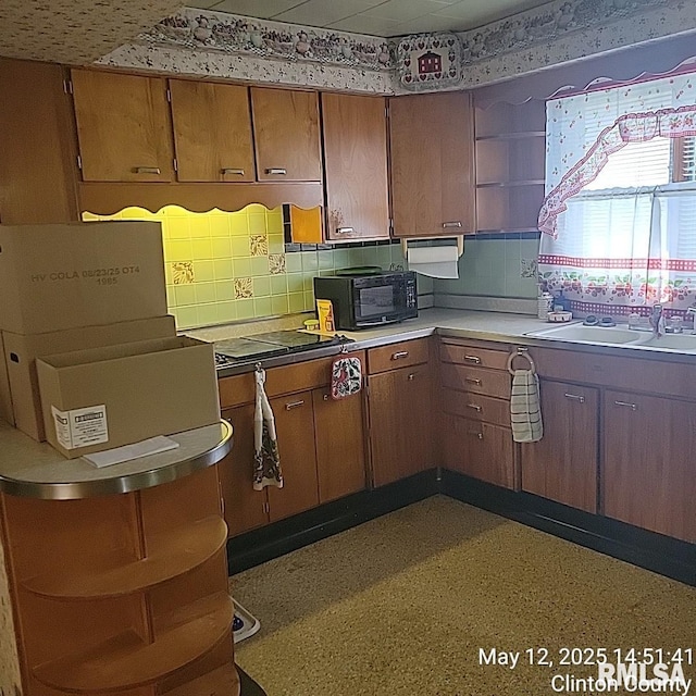 kitchen with open shelves, a sink, brown cabinets, and decorative backsplash