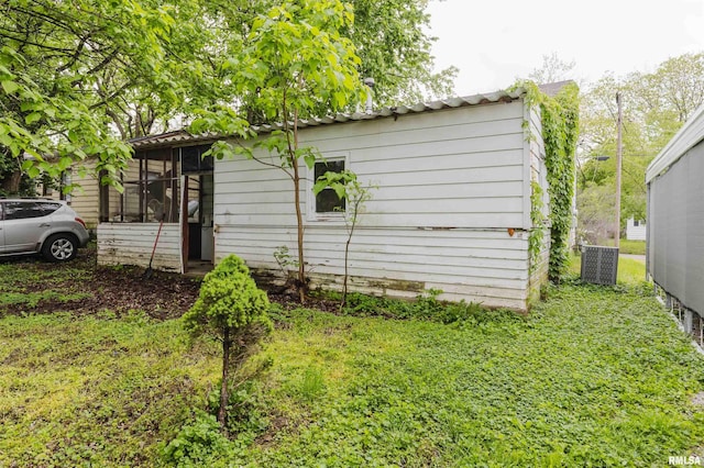 view of property exterior featuring a sunroom and central AC