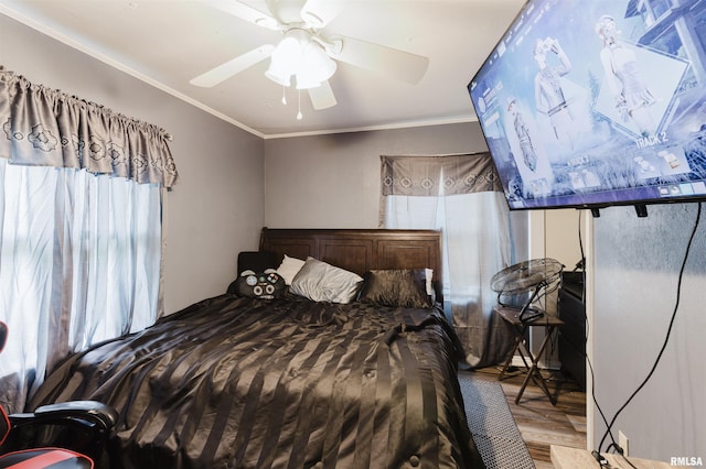 bedroom featuring wood finished floors, crown molding, and a ceiling fan