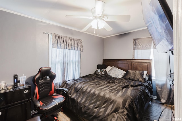 bedroom featuring crown molding, wood finished floors, and ceiling fan