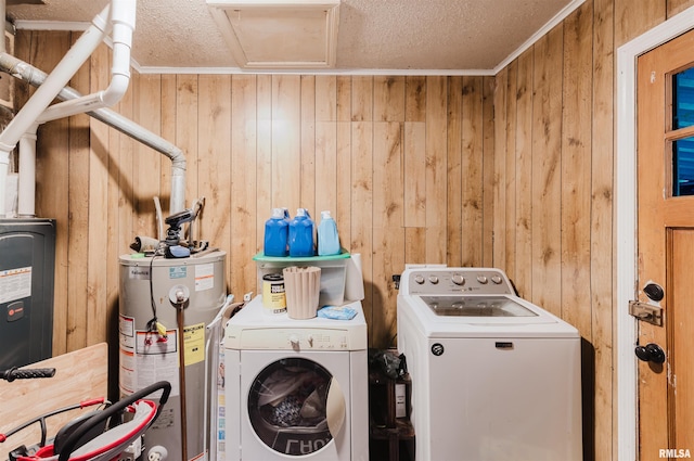 laundry room with gas water heater, washing machine and dryer, wood walls, a textured ceiling, and crown molding