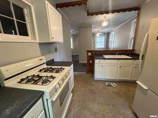 1935 12th Ave, Moline, IL 61265 - kitchen featuring white appliances, a sink, dark countertops, white cabinets, and ornamental molding