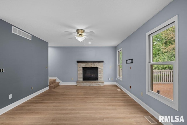 3217 Arlington Cir, Davenport, IA 52803 - unfurnished living room featuring ceiling fan, a fireplace, light wood finished floors, baseboards, and stairs