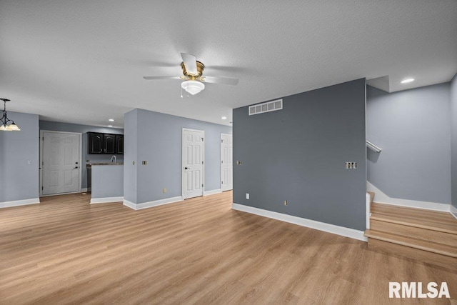 3217 Arlington Cir, Davenport, IA 52803 - unfurnished living room with light wood-type flooring, ceiling fan, baseboards, recessed lighting, and stairs