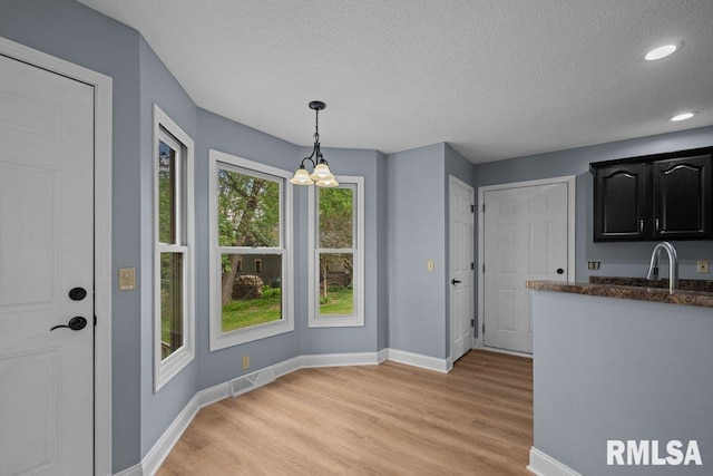 3217 Arlington Cir, Davenport, IA 52803 - unfurnished dining area with a chandelier, a textured ceiling, light wood-style floors, baseboards, and recessed lighting
