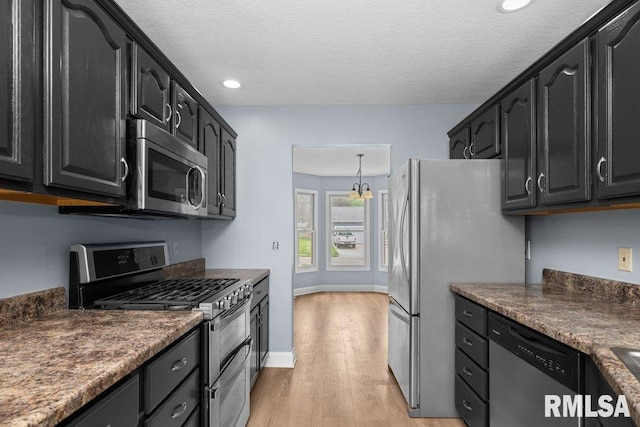 3217 Arlington Cir, Davenport, IA 52803 - kitchen with stainless steel appliances, dark cabinetry, light wood finished floors, dark countertops, and recessed lighting