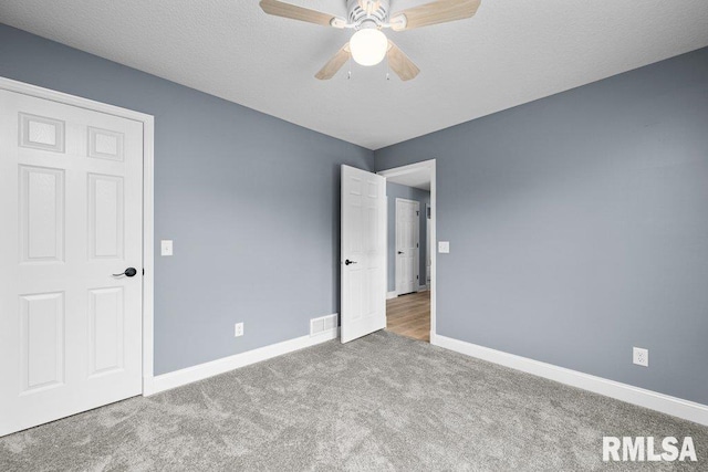 3217 Arlington Cir, Davenport, IA 52803 - unfurnished bedroom with carpet, baseboards, ceiling fan, and a textured ceiling