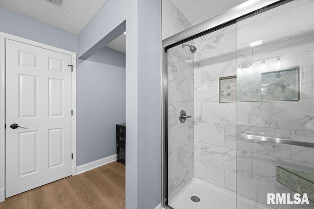 3217 Arlington Cir, Davenport, IA 52803 - bathroom with a shower stall, a textured ceiling, wood finished floors, and baseboards