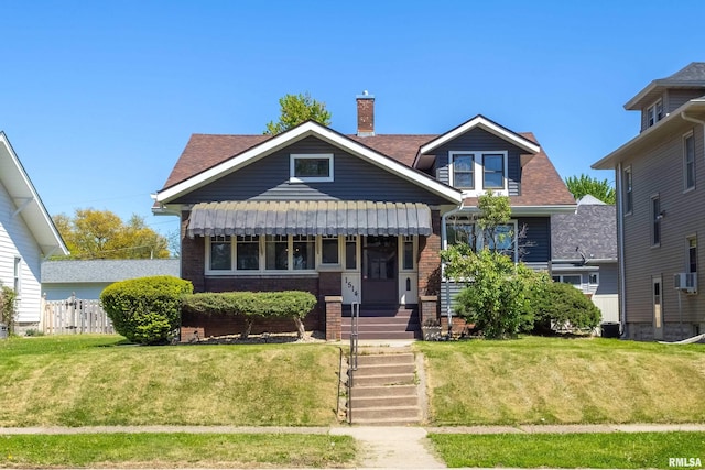 1514 16th St, Moline, IL 61265 - view of front of house featuring a front yard, brick siding, a chimney, and a shingled roof