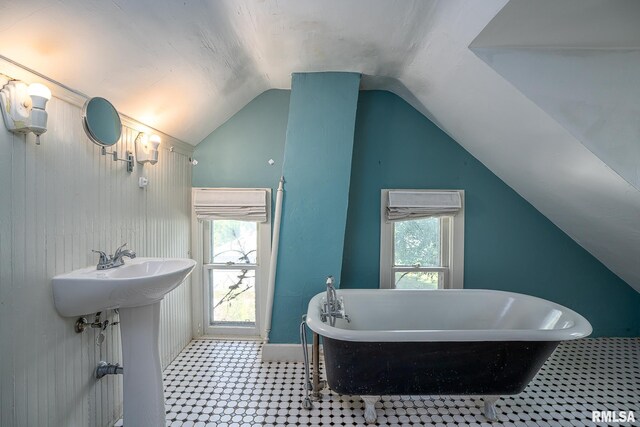 232 E 13th St, Davenport, IA 52803 - bathroom featuring vaulted ceiling, a soaking tub, tile patterned floors, a sink, and baseboards