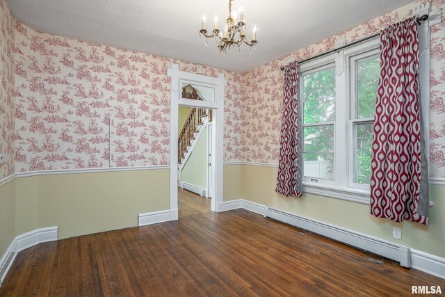 232 E 13th St, Davenport, IA 52803 - spare room featuring wallpapered walls, a baseboard heating unit, baseboard heating, a chandelier, and wood finished floors