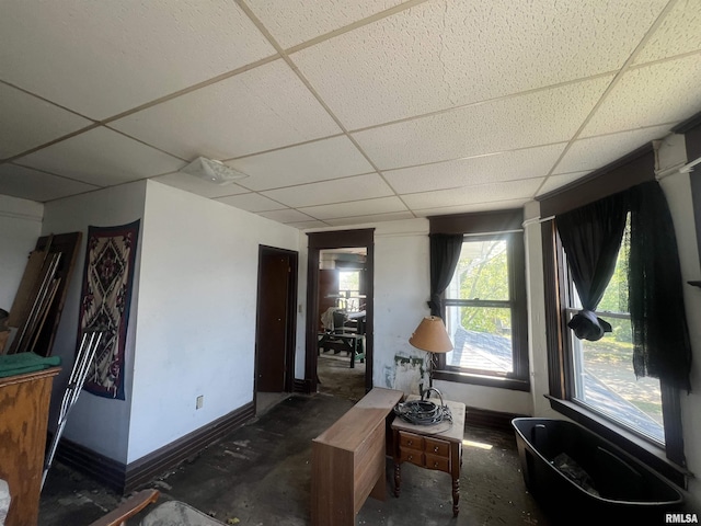 sitting room featuring a paneled ceiling and baseboards