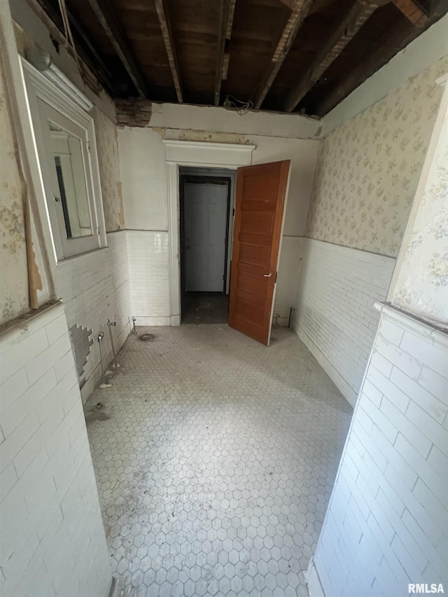 bathroom with a wainscoted wall and wallpapered walls