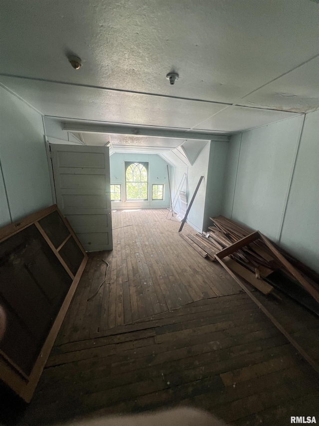 interior space with hardwood / wood-style flooring and vaulted ceiling