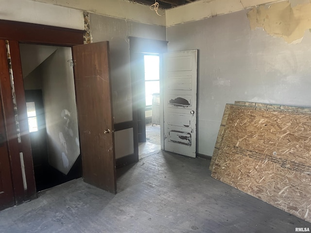 empty room featuring healthy amount of natural light and unfinished concrete flooring