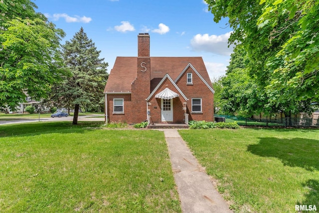 101 N Ridge St, Cambridge, IL 61238 - tudor-style house featuring a chimney and brick siding