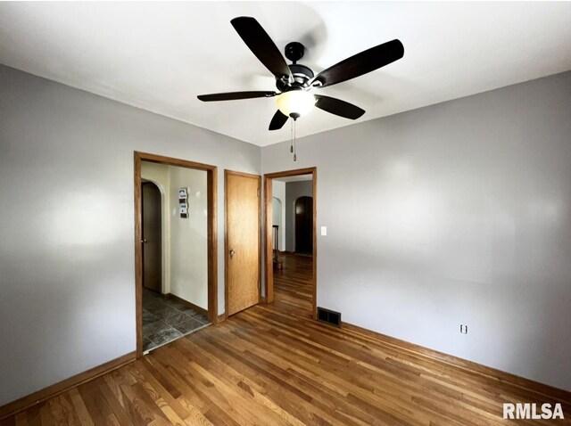 101 N Ridge St, Cambridge, IL 61238 - unfurnished room with arched walkways, wood finished floors, a ceiling fan, and baseboards