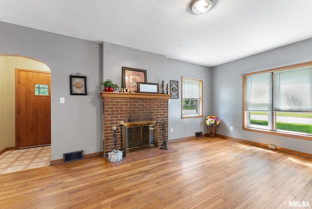 101 N Ridge St, Cambridge, IL 61238 - living room featuring arched walkways, plenty of natural light, light wood finished floors, and a brick fireplace
