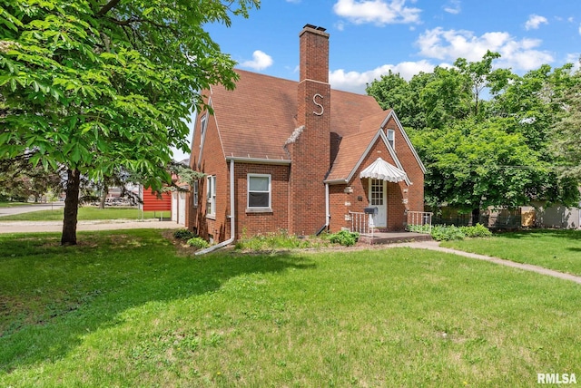 101 N Ridge St, Cambridge, IL 61238 - tudor home with brick siding, a front yard, a chimney, and roof with shingles