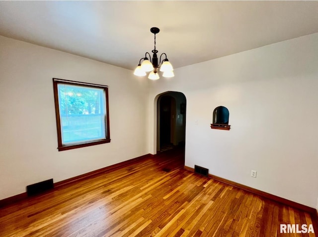 101 N Ridge St, Cambridge, IL 61238 - unfurnished room with arched walkways, a chandelier, wood finished floors, and baseboards