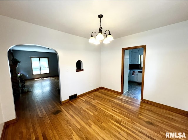 101 N Ridge St, Cambridge, IL 61238 - unfurnished room with arched walkways, hardwood / wood-style flooring, a chandelier, and baseboards