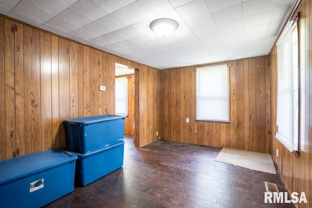 empty room featuring wooden walls and hardwood / wood-style flooring