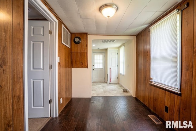 hallway with hardwood / wood-style flooring and wooden walls