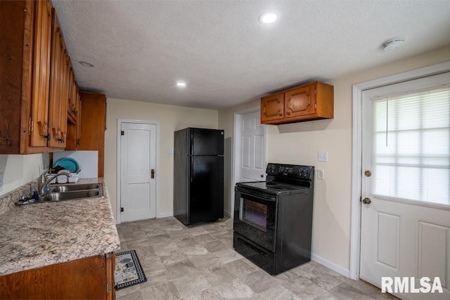 kitchen with black appliances, a sink, brown cabinetry, light countertops, and a textured ceiling
