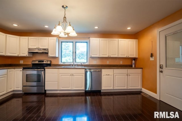 613 N 29th St, Herrin, IL 62948 - kitchen with appliances with stainless steel finishes, a sink, under cabinet range hood, a chandelier, and baseboards